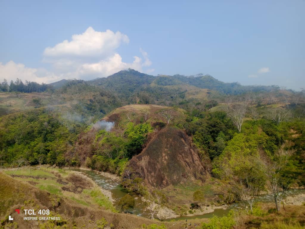Wide view of a river winding through the green hills of Kun Valley