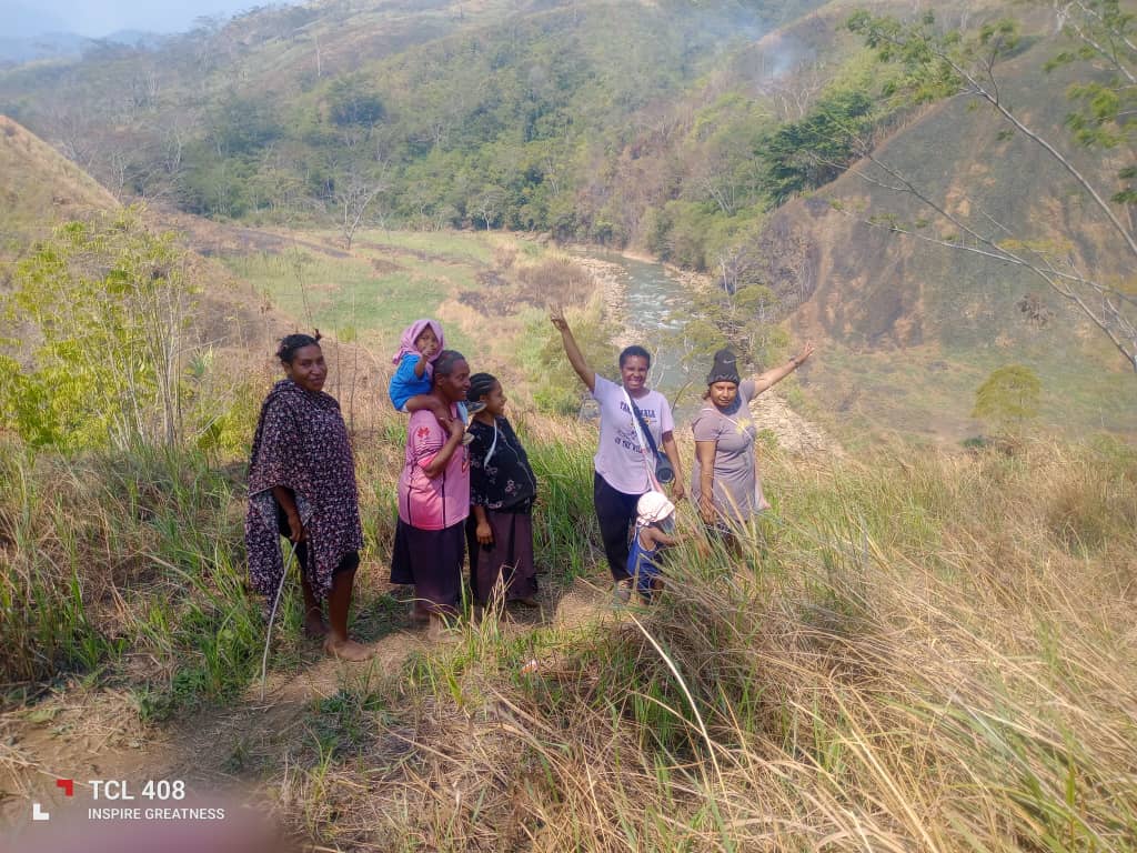 A group of people standing together on a hillside above a river in Kun Valley