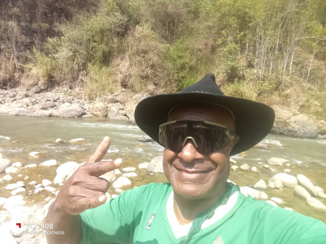 A person taking a selfie beside a rocky river in Kun Valley